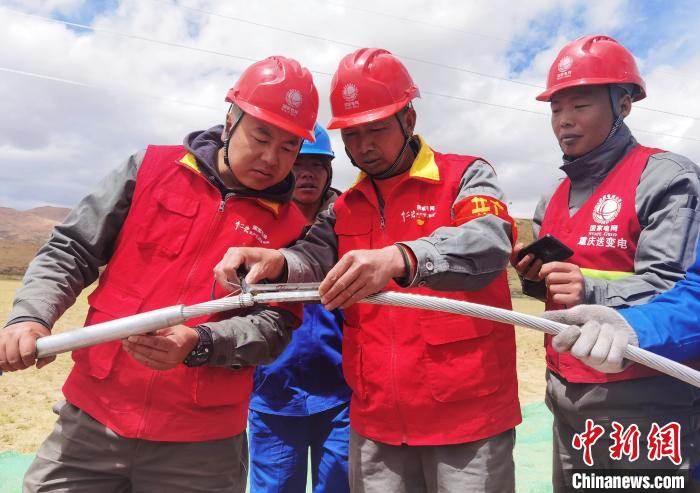 圖為阿里與藏中電網聯網工程包11標段項目部員工正在測量導線壓接尺寸。　張弛 攝